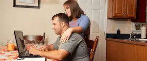 Couple looking at a laptop on their kitchen table
